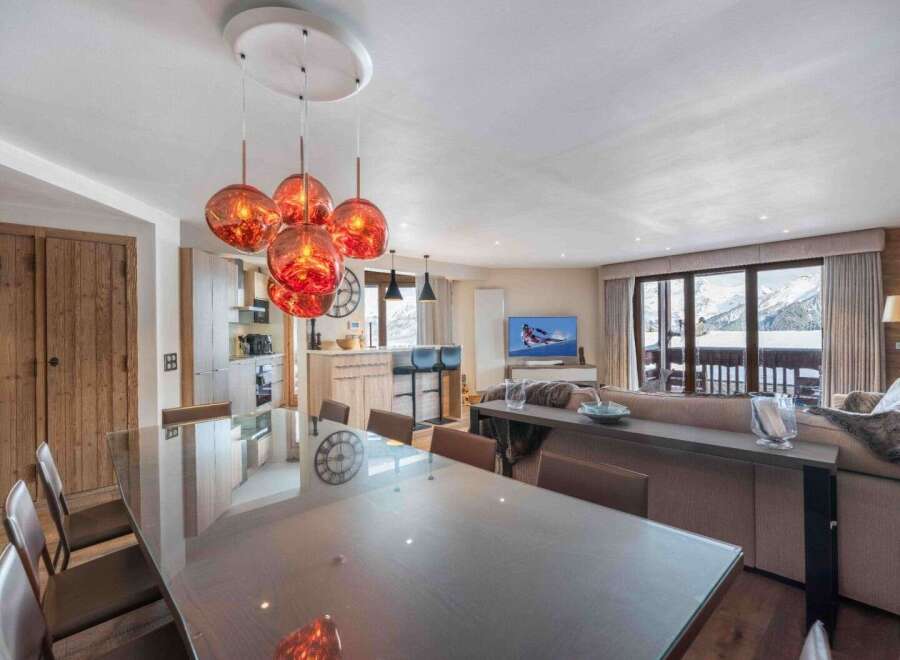 Experience luxury living in this stunning property, featuring a spacious dining area with a modern glass table and stylish pendant lighting.
