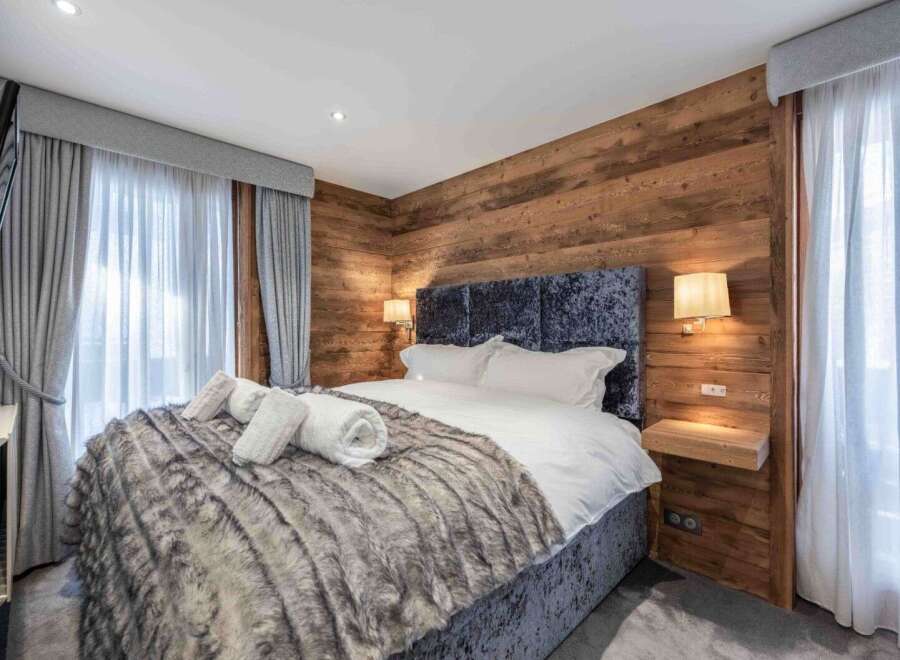Experience luxury in this stunning bedroom featuring a plush, textured bedspread and a cozy, inviting atmosphere.