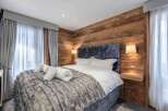Experience luxury in this stunning bedroom featuring a plush, textured bedspread and a cozy, inviting atmosphere.