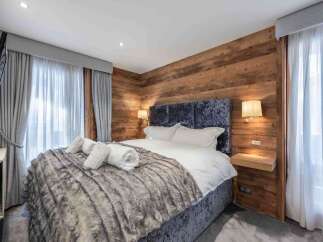 Experience luxury in this stunning bedroom featuring a plush, textured bedspread and a cozy, inviting atmosphere.