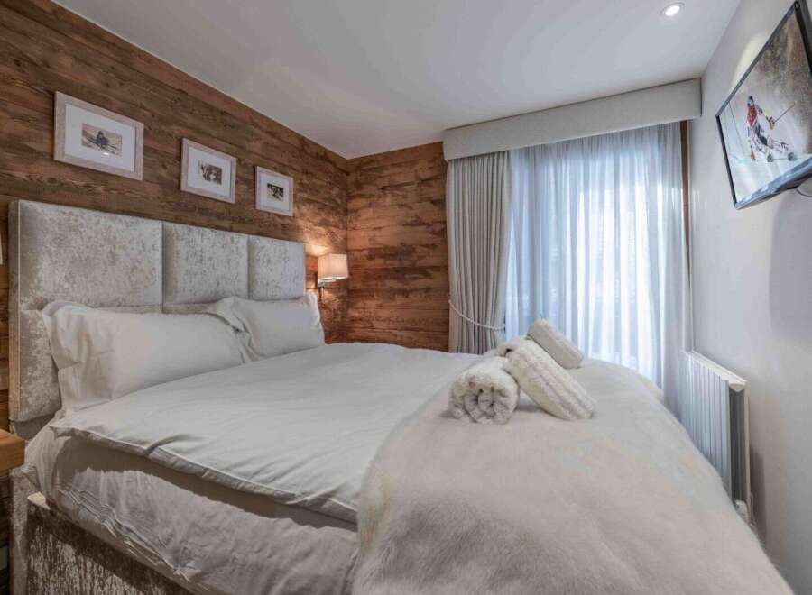 Experience luxury in this exquisite bedroom featuring a plush, upholstered headboard and a cozy, inviting bed.