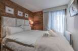 Experience luxury in this exquisite bedroom featuring a plush, upholstered headboard and a cozy, inviting bed.