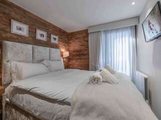 Experience luxury in this exquisite bedroom featuring a plush, upholstered headboard and a cozy, inviting bed.