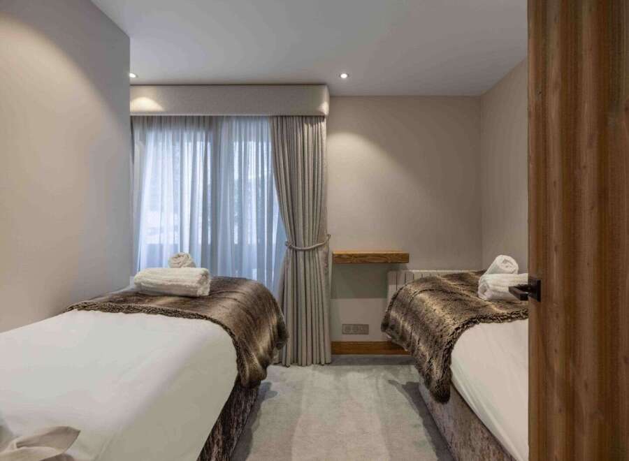 Discover tranquility in this serene bedroom, featuring two inviting beds perfect for relaxation.