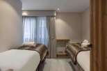 Discover tranquility in this serene bedroom, featuring two inviting beds perfect for relaxation.