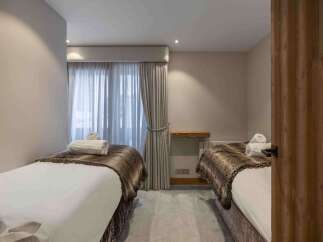 Discover tranquility in this serene bedroom, featuring two inviting beds perfect for relaxation.