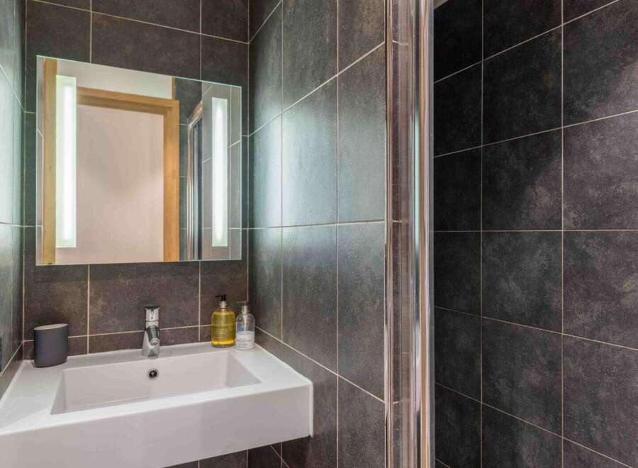 This modern bathroom features sleek, dark gray tile and a contemporary design.