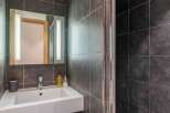 This modern bathroom features sleek, dark gray tile and a contemporary design.