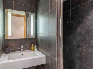 This modern bathroom features sleek, dark gray tile and a contemporary design.