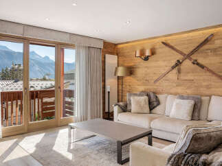 Experience luxury mountain living in this stunning alpine retreat, featuring a spacious living area with a plush sectional sofa and cozy throws.