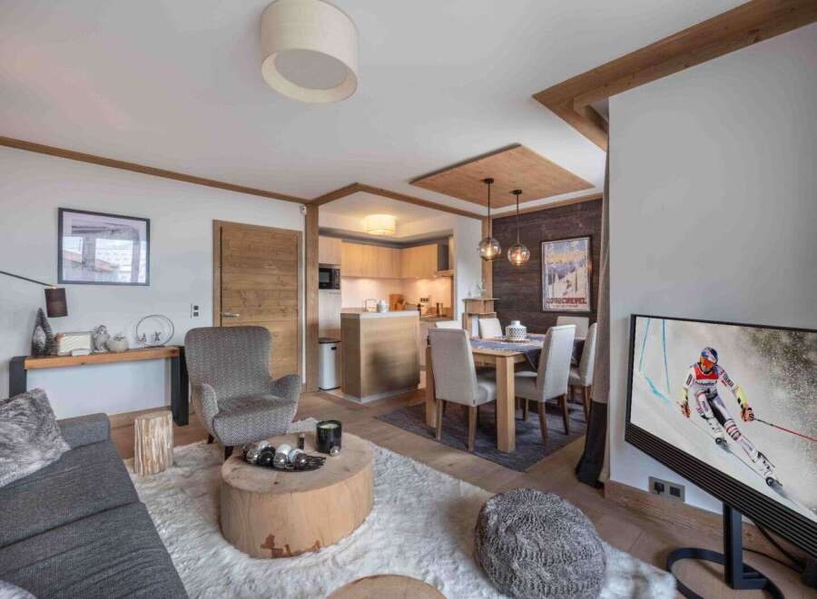 Experience luxury living in this stunning property, featuring a cozy living area with a plush rug and a modern TV.