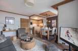 Experience luxury living in this stunning property, featuring a cozy living area with a plush rug and a modern TV.