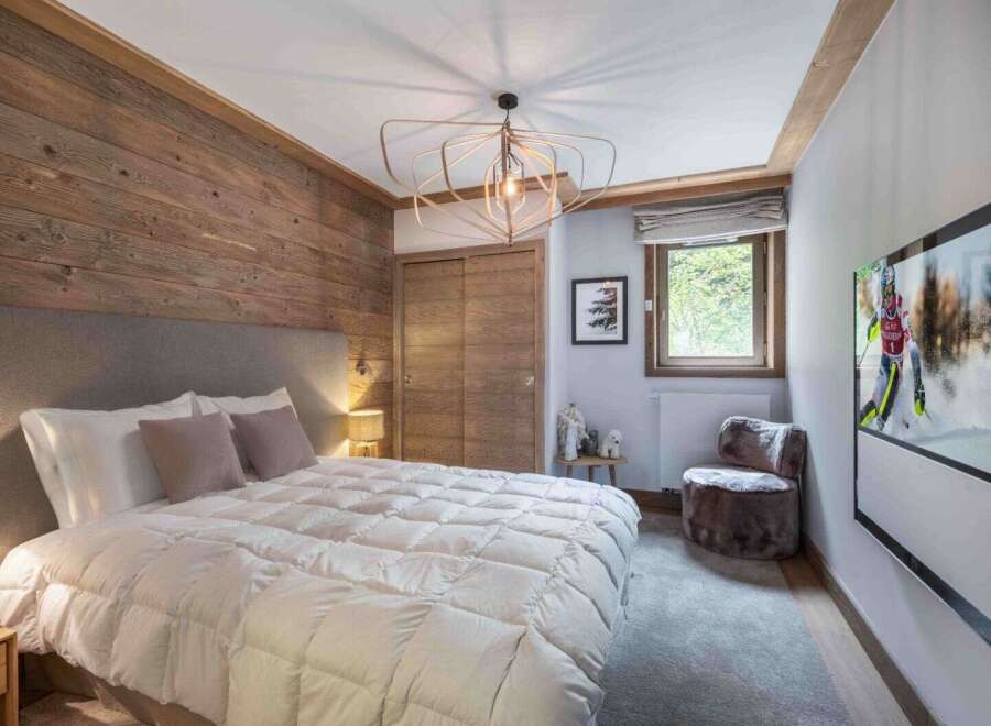 This cozy bedroom features a rustic wooden accent wall, creating a warm and inviting atmosphere.