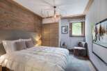 This cozy bedroom features a rustic wooden accent wall, creating a warm and inviting atmosphere.