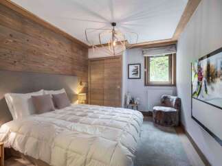 This cozy bedroom features a rustic wooden accent wall, creating a warm and inviting atmosphere.