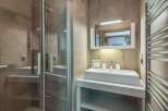 Step into a modern bathroom oasis! This stunning space features a sleek shower enclosure, a stylish vanity with a contemporary sink, and a convenient towel warmer.