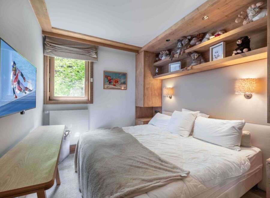 This cozy bedroom features a comfortable bed with plush pillows and a soft blanket, perfect for a relaxing retreat.
