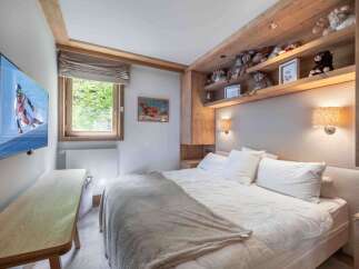 This cozy bedroom features a comfortable bed with plush pillows and a soft blanket, perfect for a relaxing retreat.