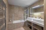 This modern bathroom features a sleek design with a double vanity and a luxurious bathtub.