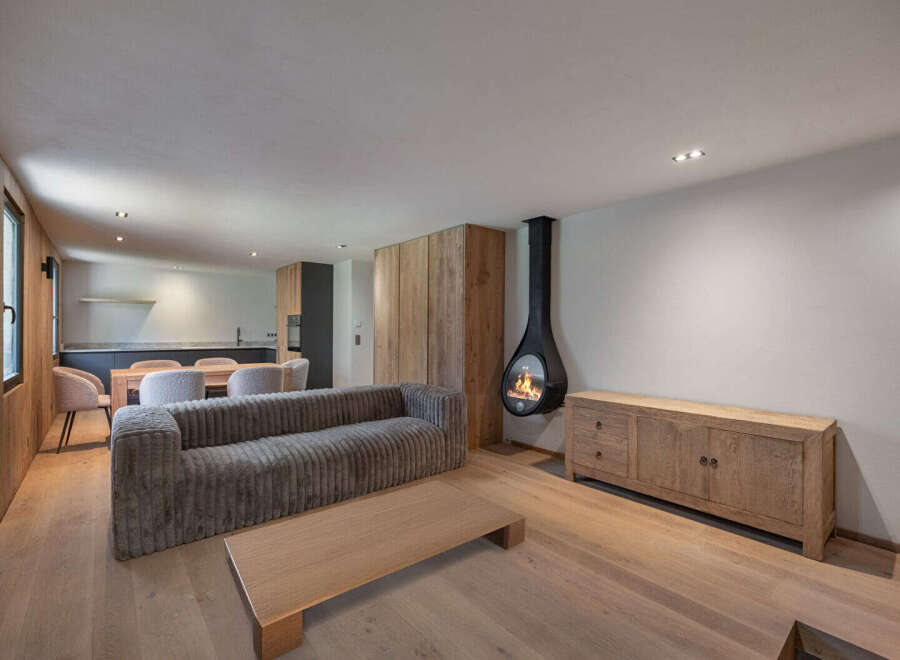 Experience modern luxury in this stunning property, featuring a cozy living area with a unique hanging fireplace.