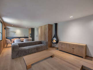 Experience modern luxury in this stunning property, featuring a cozy living area with a unique hanging fireplace.