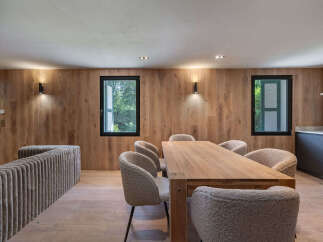 This stunning dining area features a beautiful wooden table and cozy, textured chairs, perfect for hosting gatherings.