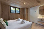 This stunning bedroom features a warm and inviting ambiance with its wooden walls and ceiling.