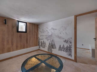 Discover a unique space featuring a stunning mountain-themed mural and a distinctive glass-covered well.