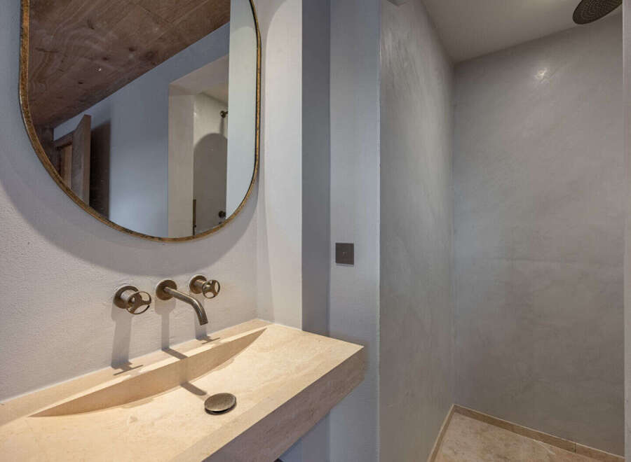 This stunning bathroom boasts a modern design with a unique stone sink and elegant fixtures.