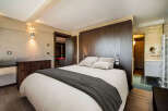 This luxurious bedroom features a cozy bed with plush pillows and a stylish dark gray throw.