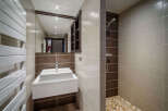 This modern bathroom features a sleek design with a floating sink and a walk-in shower.