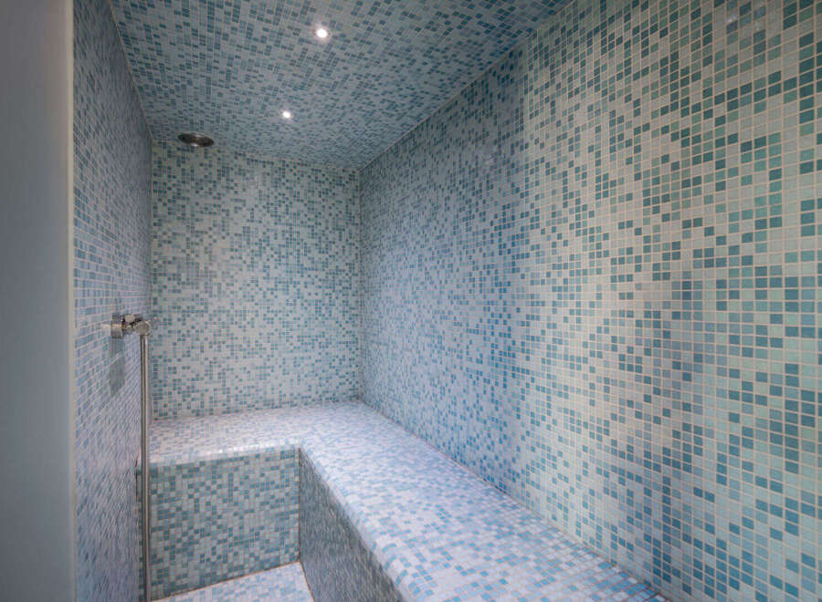 Step into luxury with this stunning steam room, featuring exquisite blue mosaic tiles that create a serene and spa-like atmosphere.