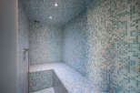 Step into luxury with this stunning steam room, featuring exquisite blue mosaic tiles that create a serene and spa-like atmosphere.