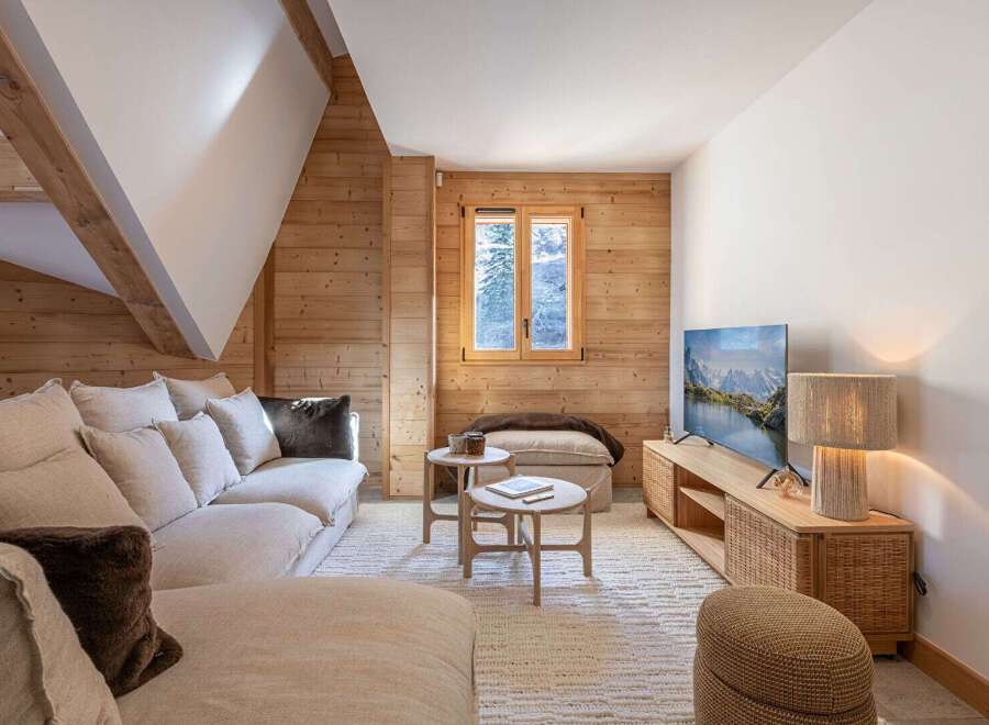 This cozy living room features a warm, inviting atmosphere with natural wood paneling and a comfortable sofa.