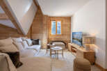 This cozy living room features a warm, inviting atmosphere with natural wood paneling and a comfortable sofa.