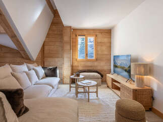 This cozy living room features a warm, inviting atmosphere with natural wood paneling and a comfortable sofa.