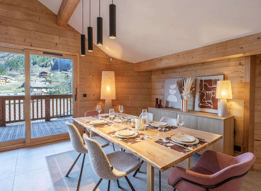 Experience the warmth of this stunning dining room, featuring a beautiful wooden table perfect for gatherings.