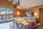 Experience the warmth of this stunning dining room, featuring a beautiful wooden table perfect for gatherings.