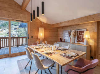 Experience the warmth of this stunning dining room, featuring a beautiful wooden table perfect for gatherings.