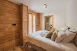 Experience the warmth of this inviting bedroom, featuring stunning wood paneling that adds a touch of rustic charm.