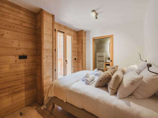 Experience the warmth of this inviting bedroom, featuring stunning wood paneling that adds a touch of rustic charm.