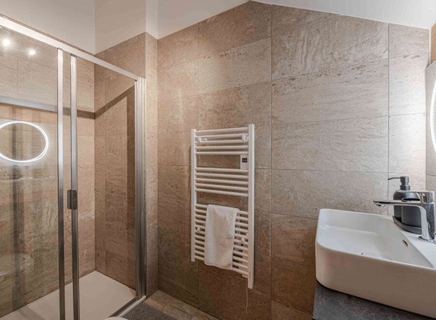 Step into luxury with this stunning bathroom! Featuring a modern shower, heated towel rack, and a sleek sink, this space is designed for ultimate comfort and style.