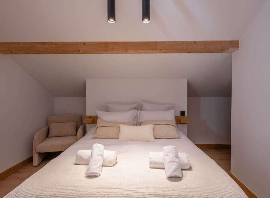 This cozy bedroom features a comfortable bed with soft linens and pillows, perfect for a relaxing retreat.