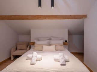 This cozy bedroom features a comfortable bed with soft linens and pillows, perfect for a relaxing retreat.