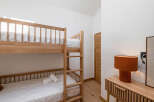 This cozy bedroom features a stylish bunk bed, perfect for accommodating guests or family members.