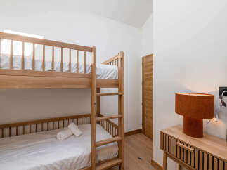 This cozy bedroom features a stylish bunk bed, perfect for accommodating guests or family members.