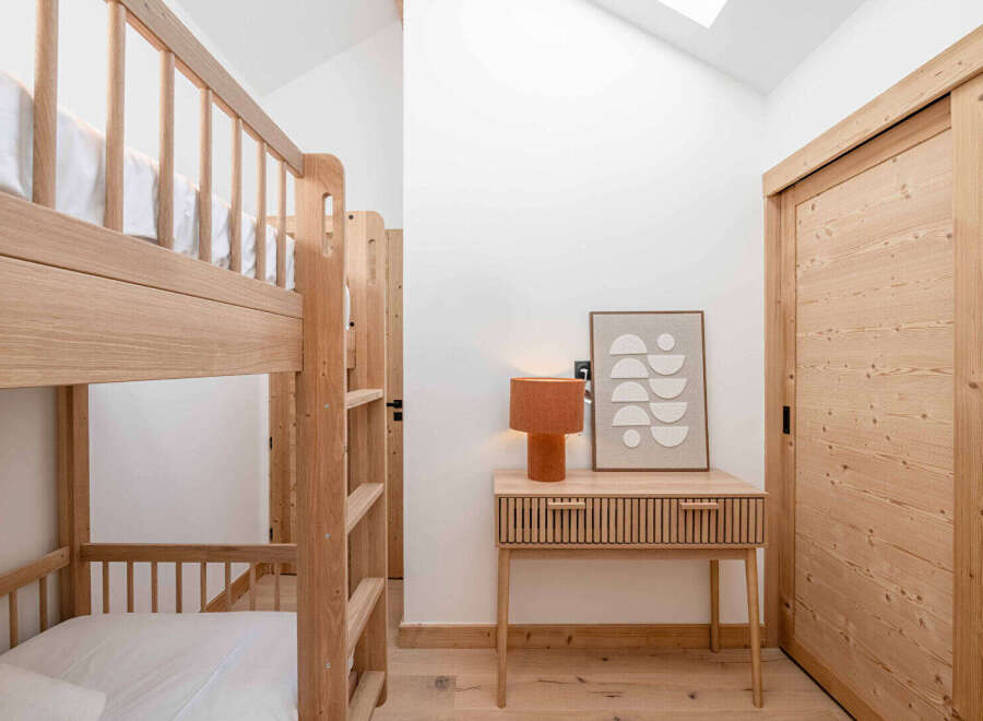 This cozy bedroom features a stylish bunk bed, perfect for accommodating guests or family members.