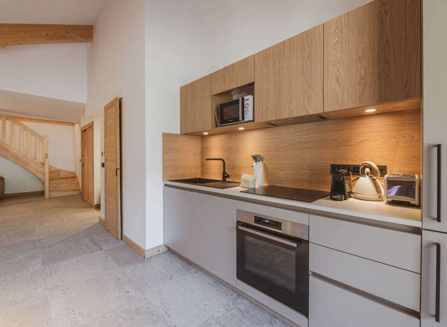 This modern kitchen boasts sleek cabinetry and a built-in microwave, perfect for preparing meals.