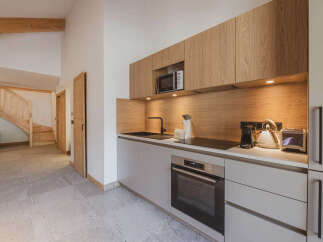This modern kitchen boasts sleek cabinetry and a built-in microwave, perfect for preparing meals.