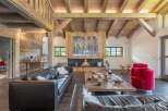 This stunning living room showcases rustic elegance with its exposed wooden beams and cozy fireplace.